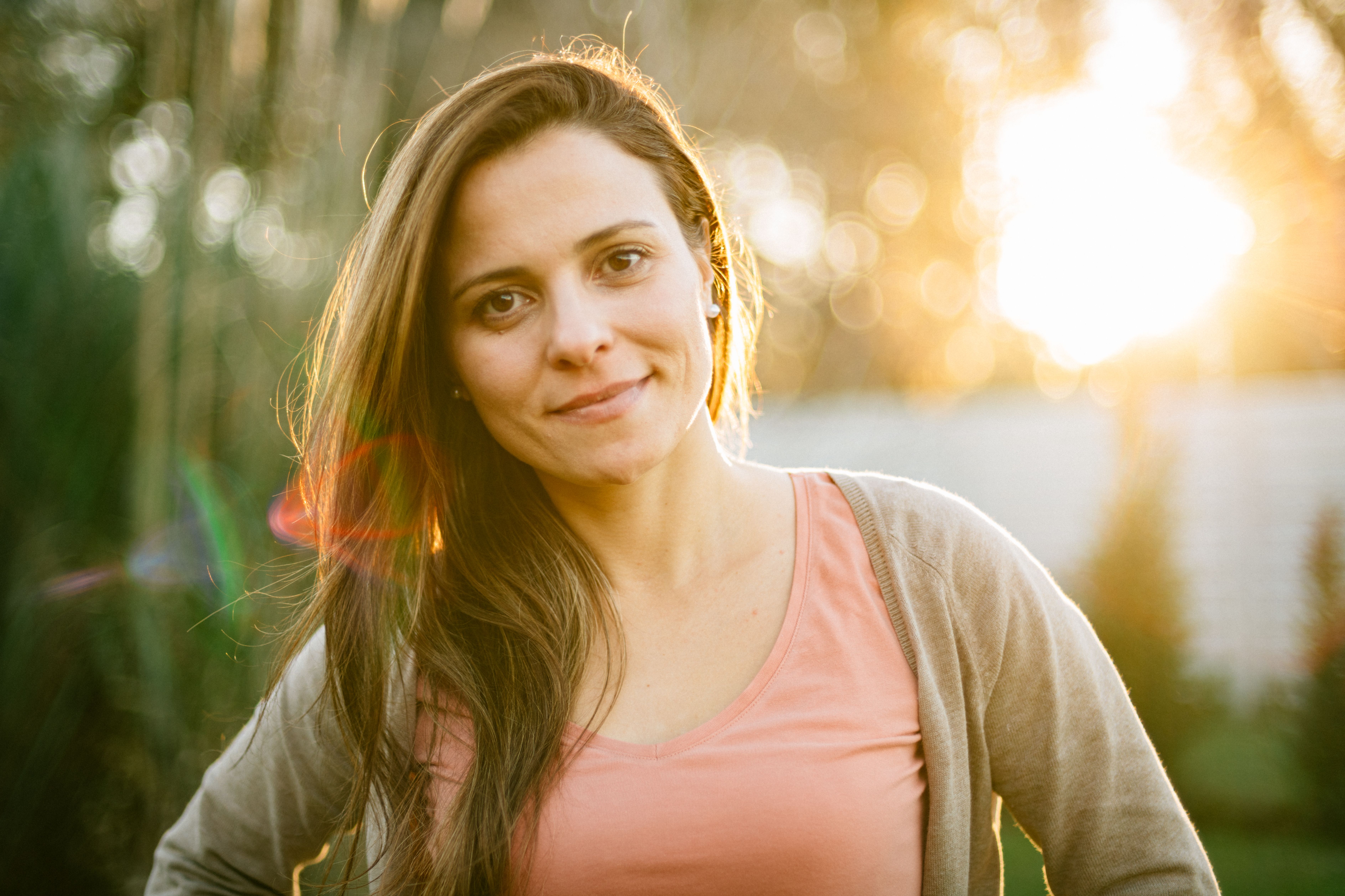 Une jeune femme sourit en plein air et recherche consciemment une relation durable via une plateforme de rencontre sérieuse.