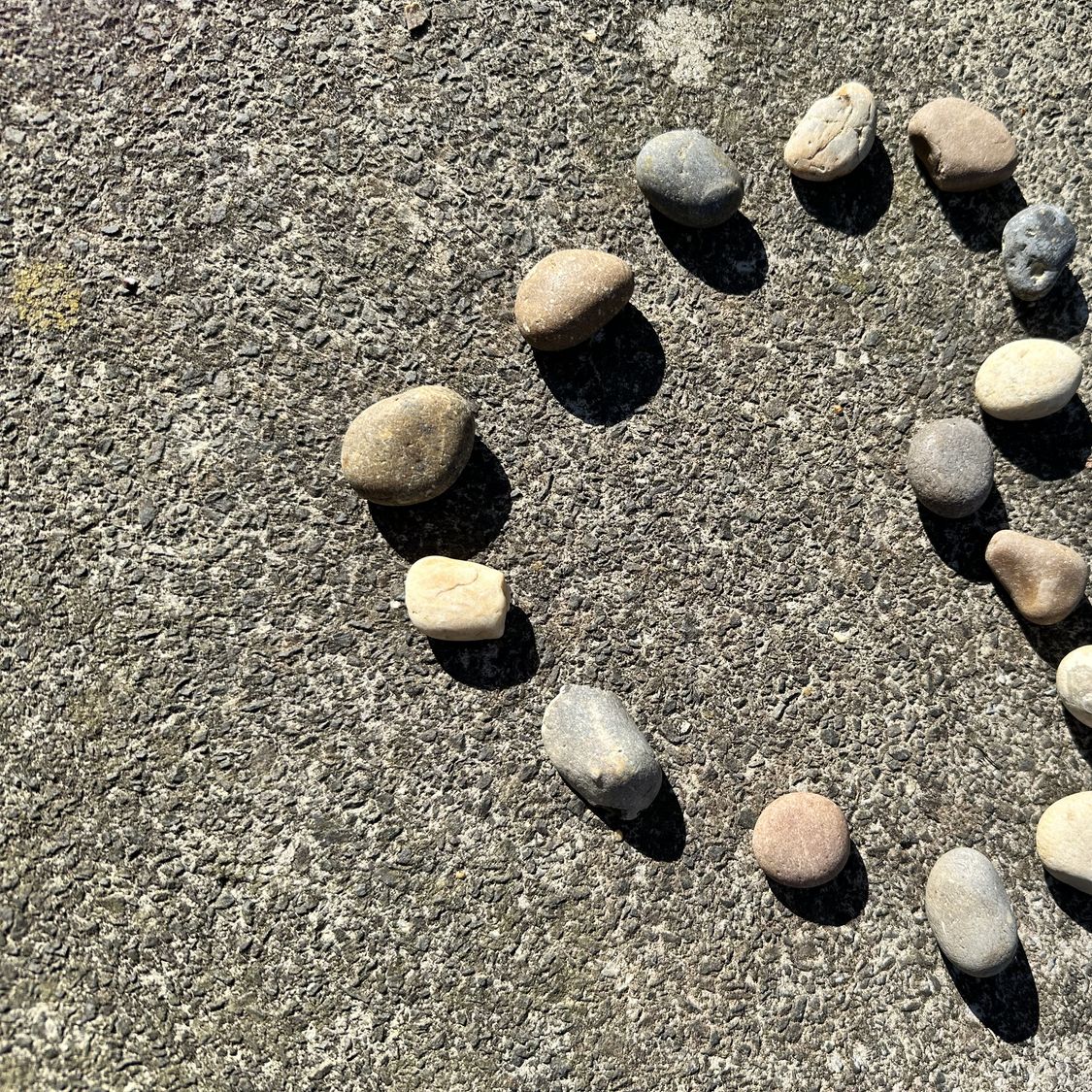 Petites pierres formant un cœur sur le sable d’une plage, symbole d’une rencontre après 50 ans, d’une relation durable et de l’amour partagé.