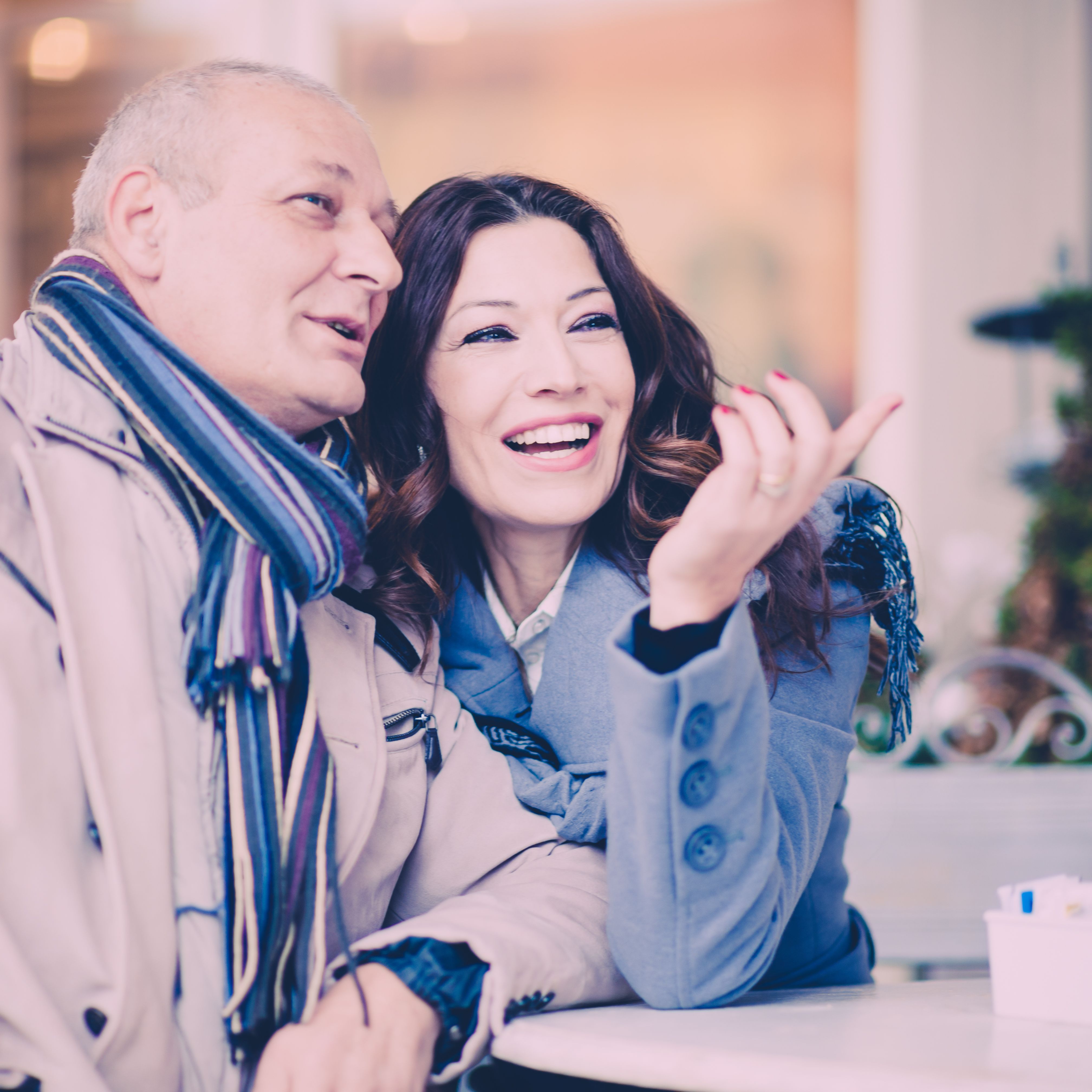 Homme et femme d’une cinquantaine d’années échangeant avec le sourire lors d’un premier rendez-vous, illustrant une rencontre après un divorce et le début d’une relation sérieuse.